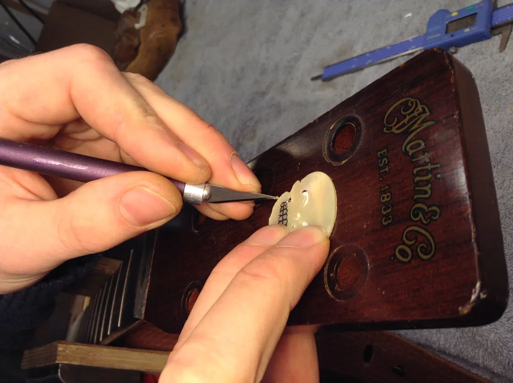 Tracing the outline with a sharp blade.
